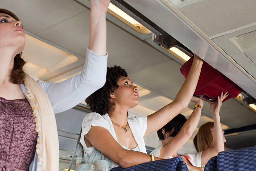 How to Put Your Luggage in the Overhead Bin, According to a Flight Attendant Essence